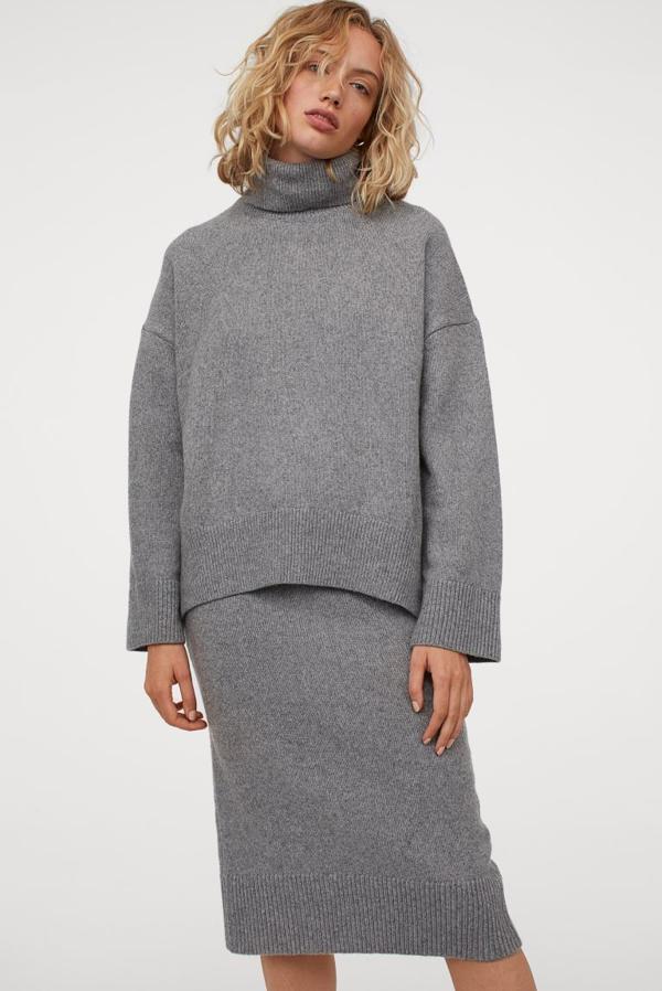 Esta falda de H&M disponible en gris claro y en beige está confeccionada con poliéster reciclado en punto suave con lana en la trama, es de talle alto y tiene la cintura elástica revestida y ribete ancho de canalé en el bajo con abertura posterior. Solo queda en la talla XS y cuesta 24,99 euros.