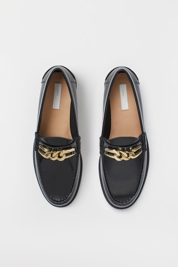 Con cadena dorada en el empeine, estos mocasines de piel en negro de H&M cuestan 59,99 euros y están disponibles únicamente en los números 41 y 42.