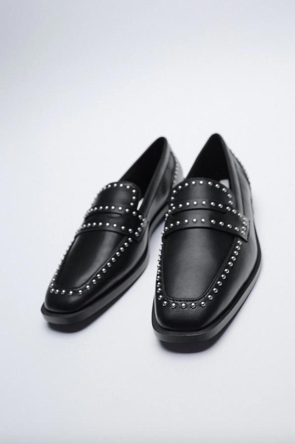 Detalle de tachas en el corte y antifaz en la parte delantera, estos mocasines de Zara en color negro tienen un precio de 25,95 euros y están disponibles entre los números 35 y 42.
