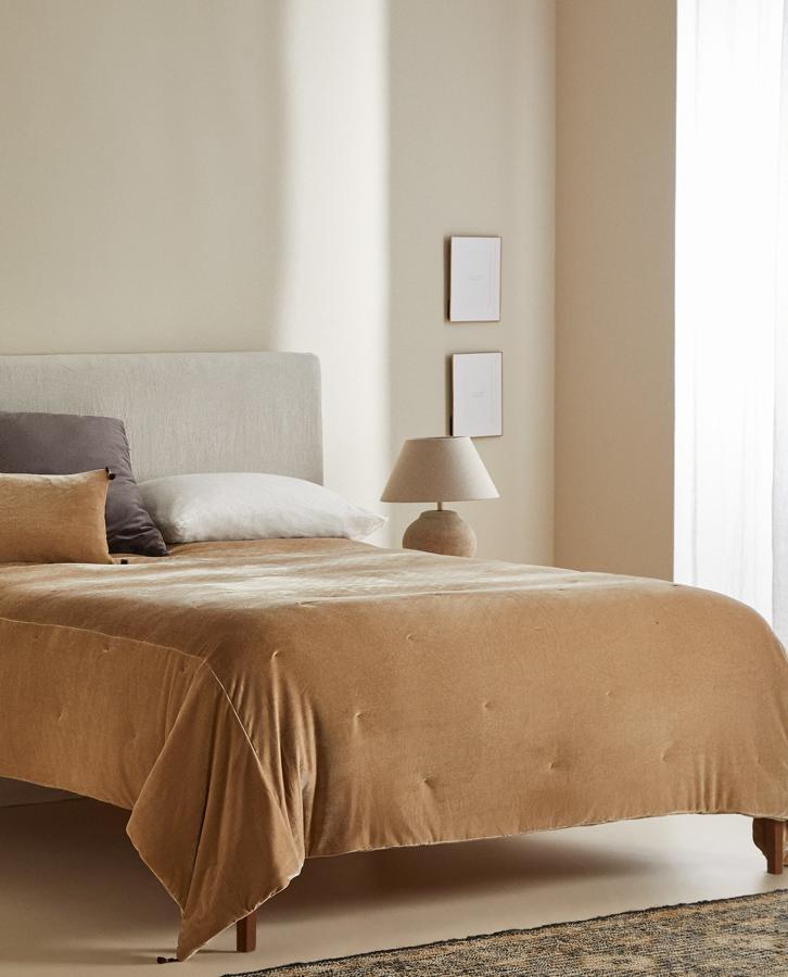 Disponible en tostado o marrón, este edredón de terciopelo acolchado con medidas de 230x250 centímetros cuenta con detalle de pompones en los bordes y tiene un precio rebajado de 79,99 euros.