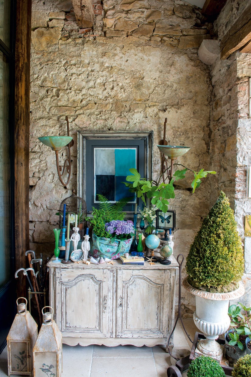 Entrada a la casona, con mueble decapado provenzal, y retrato de Marta de la Rica.