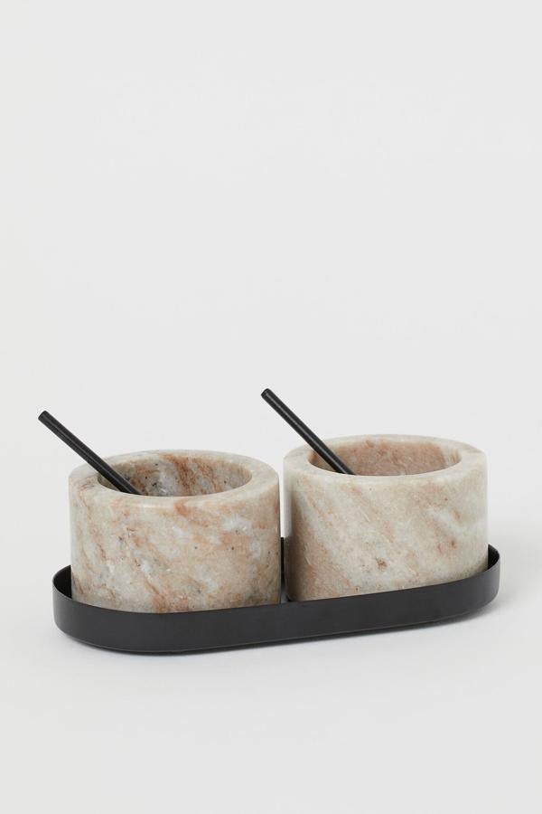 Estos cuencos pequeños de piedra en color beige cuentan con cucharilla y una bandeja ovalada a juego y tienen un precio de 19,99 euros.