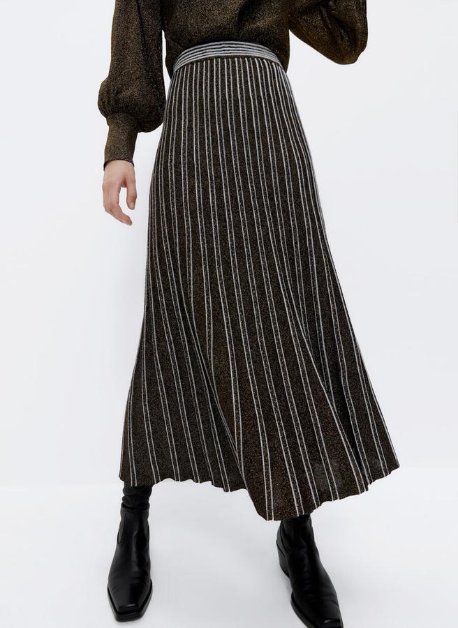 Confeccionada en punto trabajado con efecto listado vertical, esta falda midi viene con cintura elástica y detalle de hilo fantasía metalizado. De 79 euros ha pasado a costar 39,95 euros y está disponible en las tallas S y M.