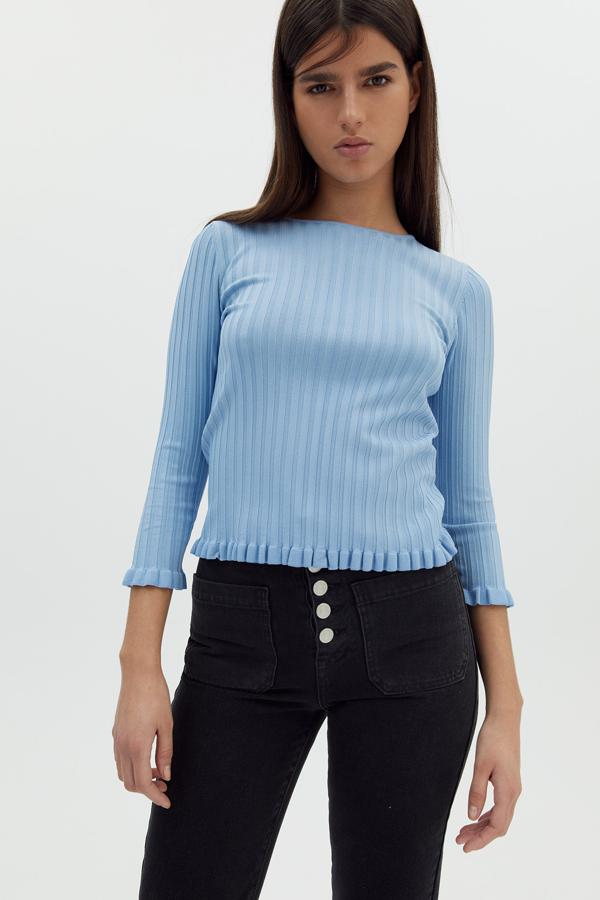 Este jersey de canalé con cuello caja está disponible en azul o en verde caqui. Con detalle de volantes en las mangas, tiene un precio de 15,99 euros.