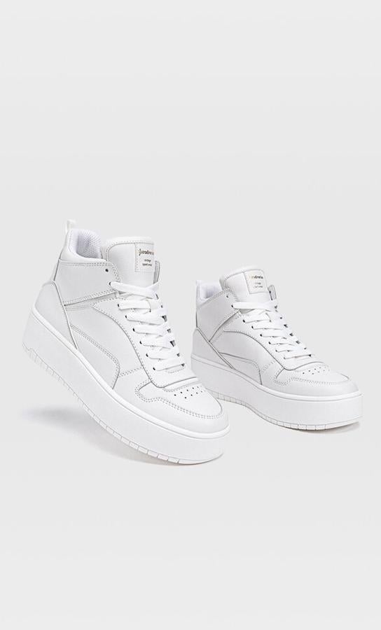 Con diseño de botín tipo basket, estas sneakers blancas cuentan con detalles de pespuntes y perforados y tienen un precio de 29,99 euros. Son de Stradivarius.