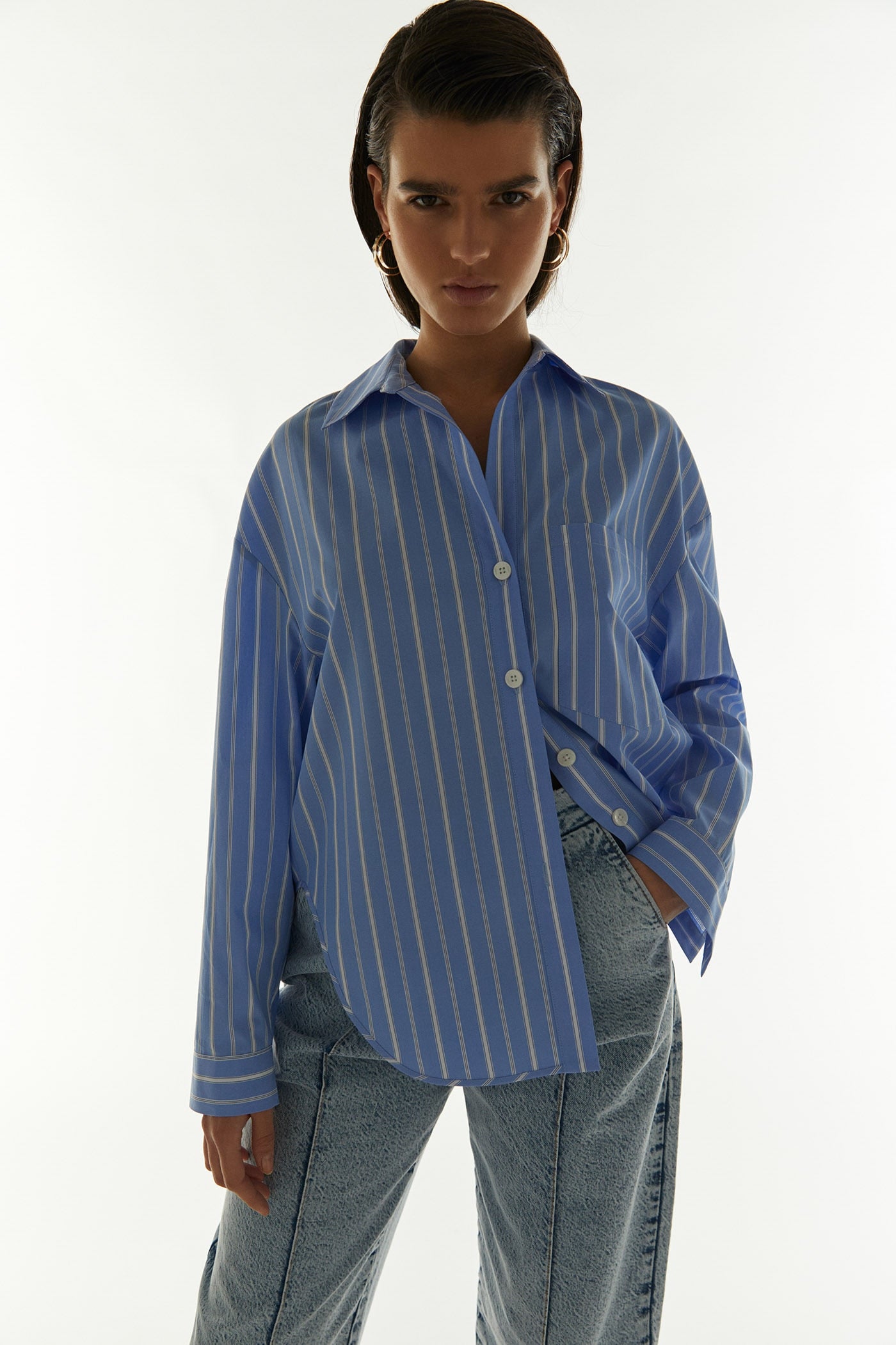 Camisa de rayas oversize en color azul bebé. Un must de la temporada que no dejaremos de ver a las chicas que más saben de moda con todo tipo de vaqueros. (29,99 euros).