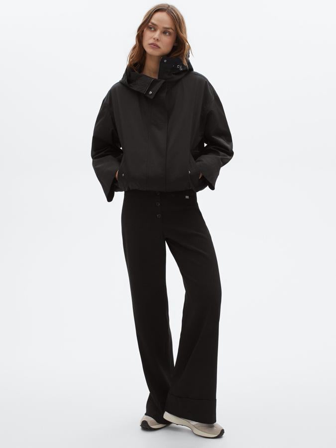 Confeccionada en algodón con materiales repelentes al agua, esta parka corta en color negro de corte casual viene con cuello alto y capucha ajustable, dos bolsillos de solapa y cierre mediante cremallera oculta por tapeta con bajo ajustable mediante cordones. Tiene un precio de 99,95 euros y estará disponible entre las tallas XS y L.