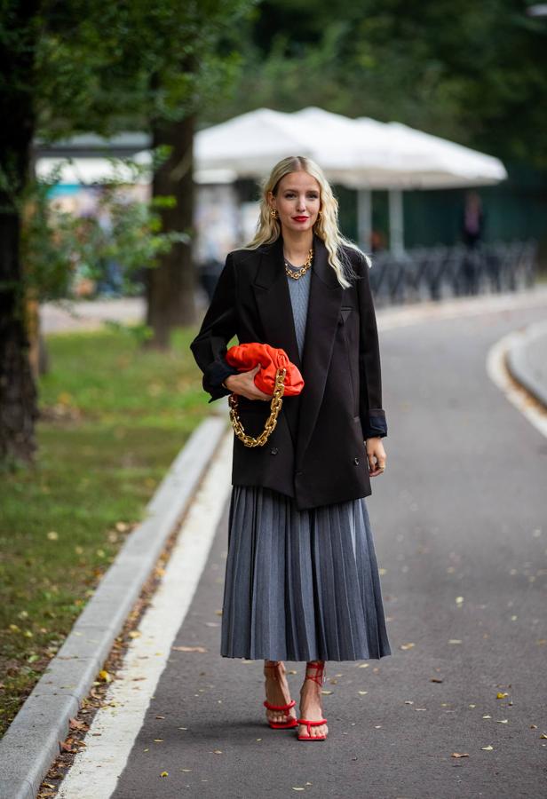 La apuesta lady también funciona con una maxi blazer que, engamada en tonos azules con un vestido midi plisado pone el acento en los accesorios, en tonos naranja y dorado.