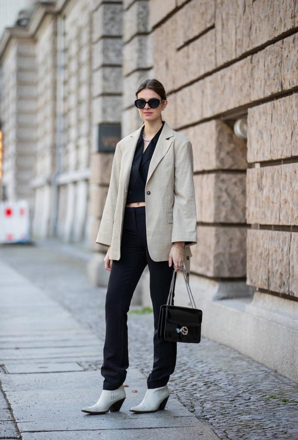 Un estilismo informal declinado en blanco y negro, con una blusa cropped y unas botas estilo cowboy.