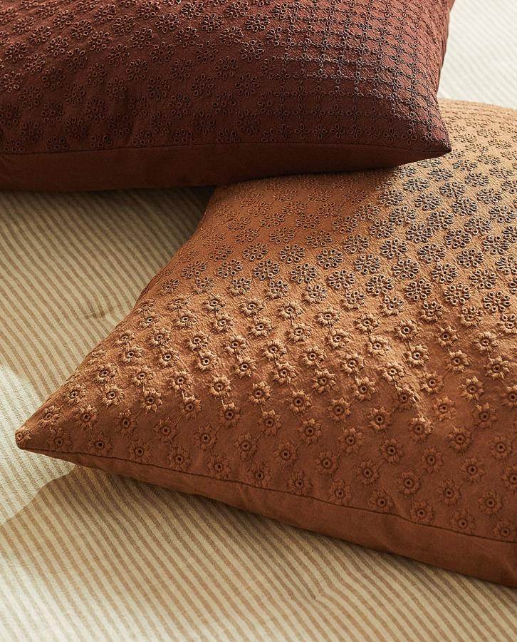 Disponible en varios colores, esta funda de cojín bordada de 45x45 centímetros tiene un precio rebajado de 9,99 euros.