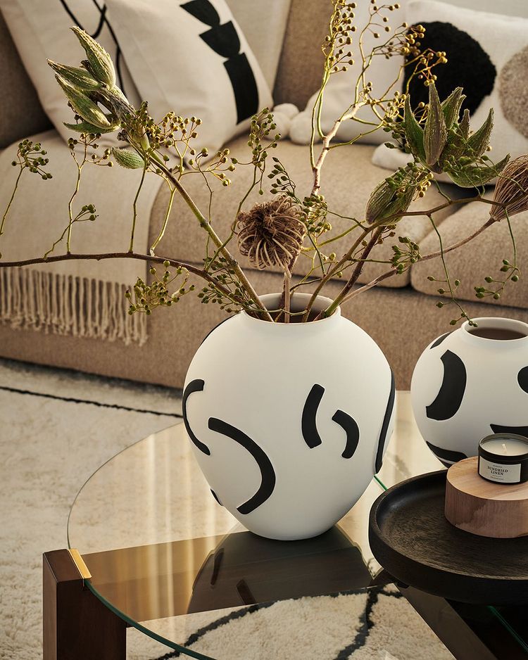 Arte en cada rincón de tu salón, con piezas tan especiales como este juego de jarrónes de cerámica pintada, disponibles desde 17.99 euros en H&M Home. Los cojines para completar el espacio cuestan entre 4.99 y 9.99 euros.