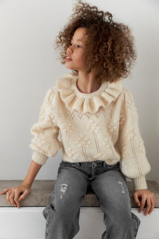 Este jersey súper romántico con bodoques y cuello con volante es uno de nuestros favoritos de la temporada. Es de Zara Kids y cuesta 22.95 euros.