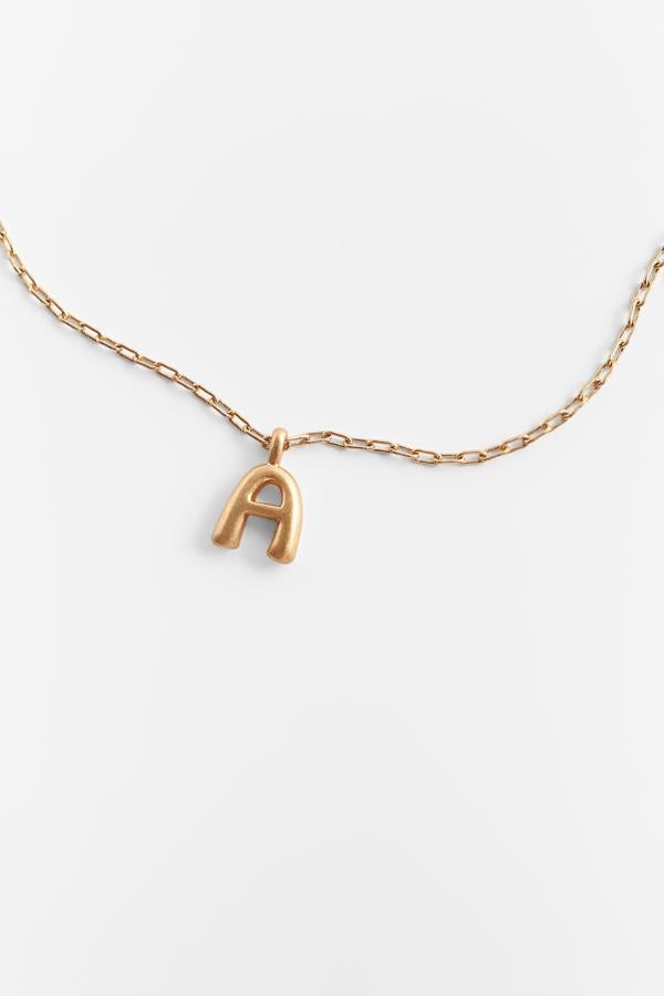 Colgante con inicial realizado en latón y acero de la nueva colección de primavera de Zara (12,95 euros)