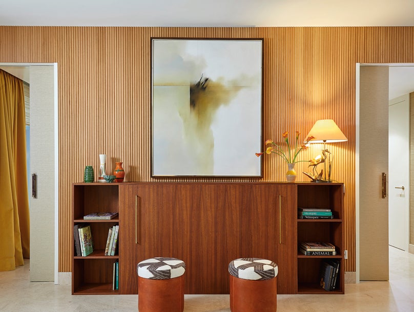 La cómoda es un diseño de Melíán Randolph y esconde una televisión. La pared está panelada en madera.