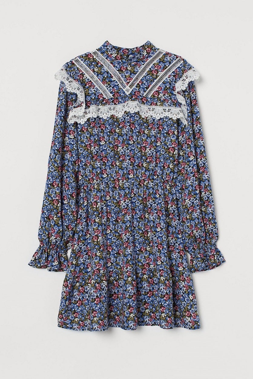Vestido mini con estampado de flores y un cuello alto que combina volantes, canesú y encaje. Las botas no se resistirán. (34,99 euros).