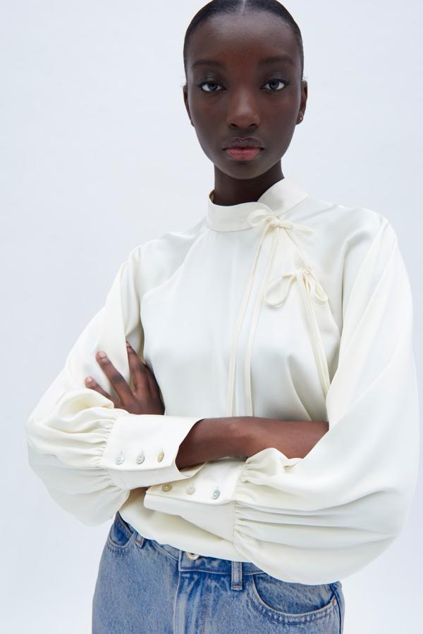 Blusa satinada con cuello mao y lazos, de Zara (25,95 €).