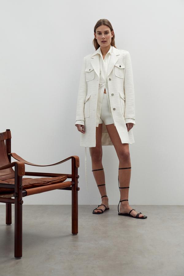 Este abrigo de entretiempo de inspiración sahariana en bouclé blanco con detalle de cinturón cuesta 59.99 euros en Sfera.