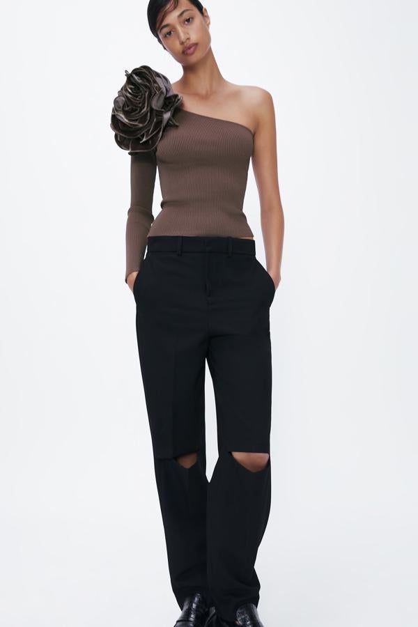 Top asimétrico de manga larga con flor de tela bordada en el hombro, de Zara (5,99 €).