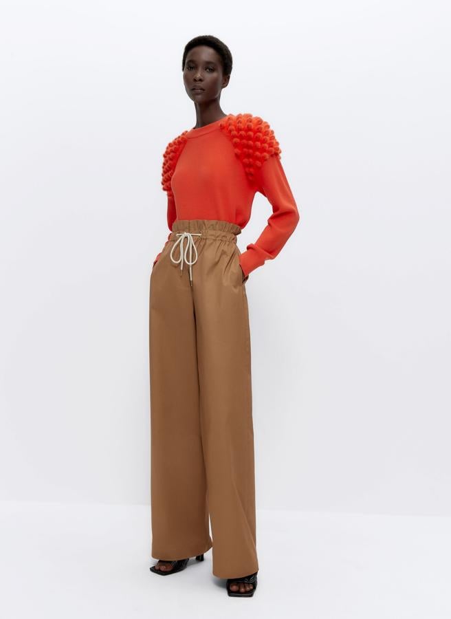 Uterqüe también apuesta por el naranja para este jersey con cuello redondo y detalles de punto fantasía a contraste en los hombros. Con acabados en rib, cuesta 69 euros y en la página web se ha agotado en todas las tallas.