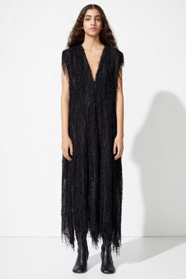 De diseño recto, confeccionado en tejido holgado con flecos, este vestido negro viene con escote de pico pronunciado y hombreras, falda recta con suave caída y bajo asimétrico más largo en los laterales. Con largo hasta el tobillo y forrado en gasa, tiene un precio de 129 euros, está disponible entre las tallas 32 y 46.