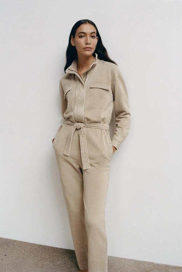 Confeccionado en algodón orgánico en color caqui claro, este mono de Zara con cuello redondo subido y mangas largas acabadas en puño viene con bolsillos de plastrón con solapa en la pechera y bolsillos laterales ocultos en la costura. Con cinturón a tono, podemos encontrarlo entre las tallas XS y L por 39,95 euros.
