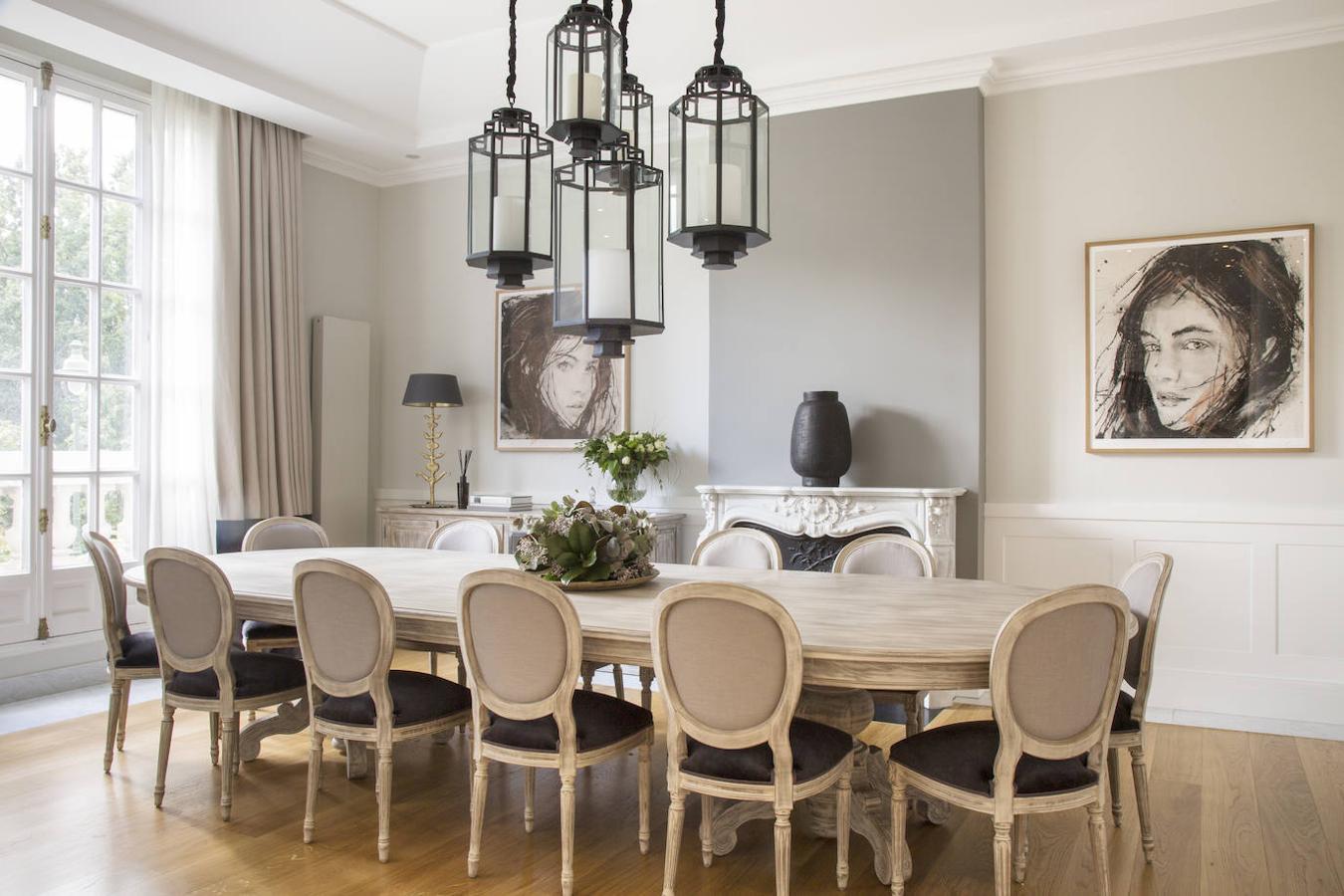 Comedor con chimenea. Las lámparas de techo son de Elctholtz y el cuadro, de Lidia Masllorens. Mesa y sillas de Guadarte con tapicería de Gancedo.