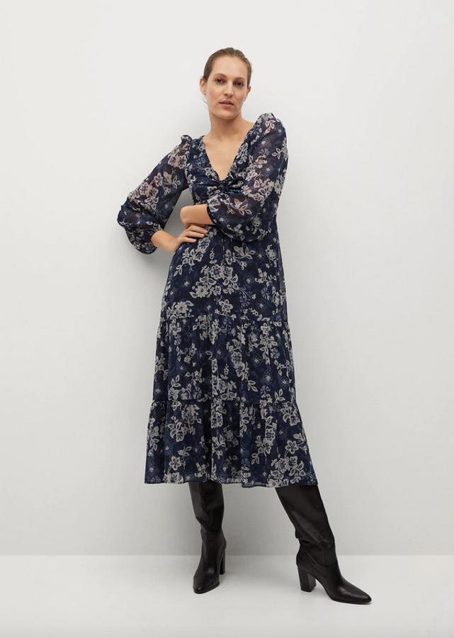 Estampado de flores en tonos grises sobre fondo azul marino para este vestido midi de Mango con diseño acampanado, detalle fruncido en el escote de pico y mangas largas abullonadas con puños elásticos y volante en el bajo. Podemos encontrarlo entre las tallas XS y XL por 49,99 euros.