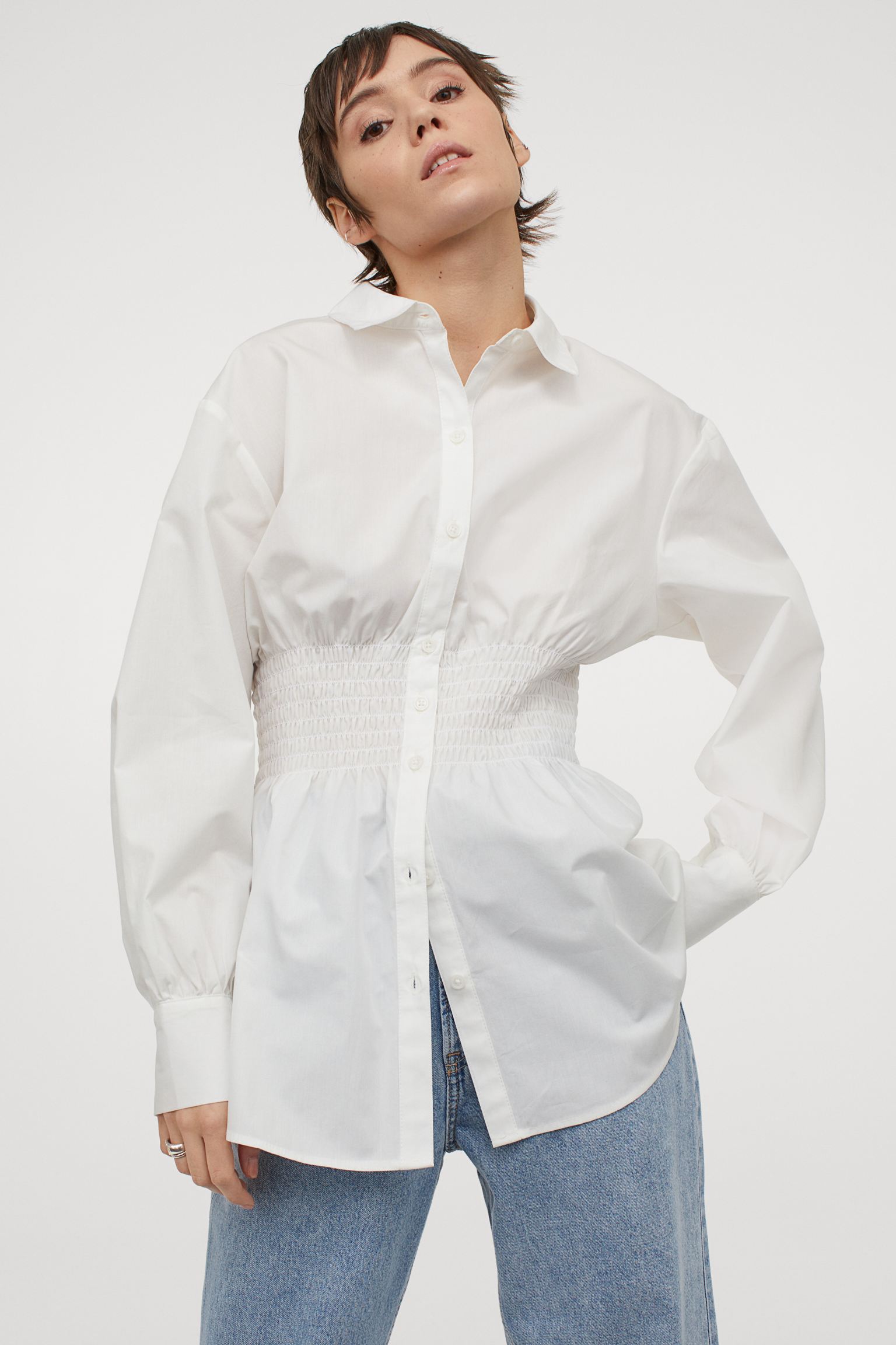 Camisa blanca amplia de algodón con cintura fruncida de la nueva colección de H&M. (19,99 euros).