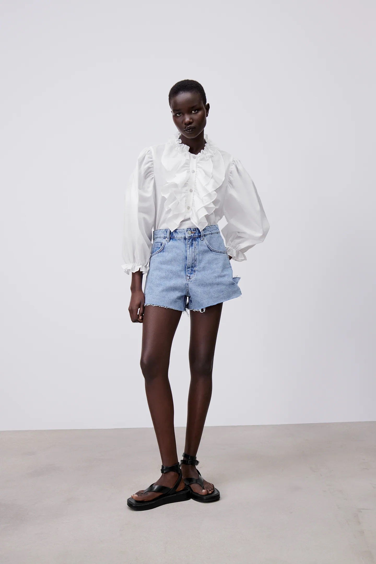 Cuello con volantes y botones joya. ¿Te atreves con la camisa blanca más romántica y barroca de la lista? Está en Zara y cuesta 25,95 euros.