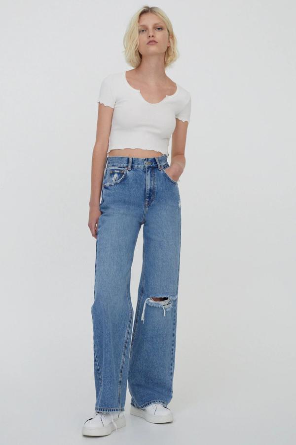 Confeccionados en 100% algodón, estos jeans flare de tiro alto de color azul cuentan con cinco bolsillos, cintura con trabillas y detalle de roto. Son de Pull & Bear y tienen un precio de 29,99 euros.
