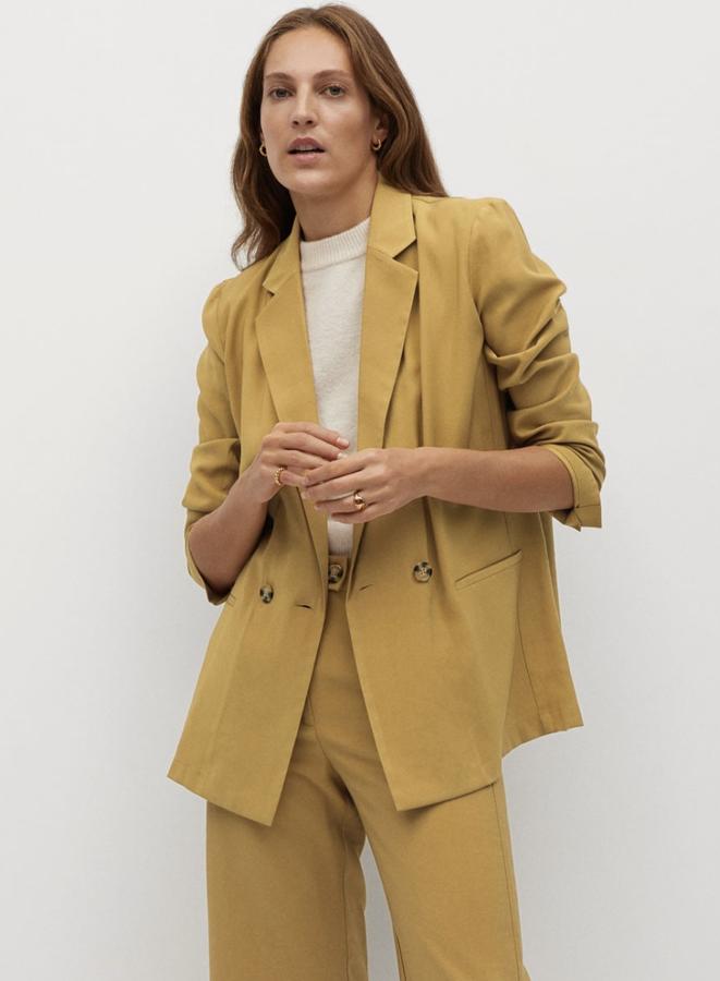 En color mostaza, aunque también está disponible en azul marino, esta americana fluida con diseño cruzado y manga larga con aberturas en los puños tiene un precio de 39,99 euros.