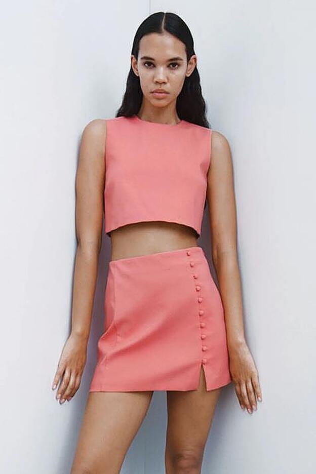 ste top corto con manga sisa cuenta con botones forrados en la parte trasera, a juego con el detalle de la falda.
