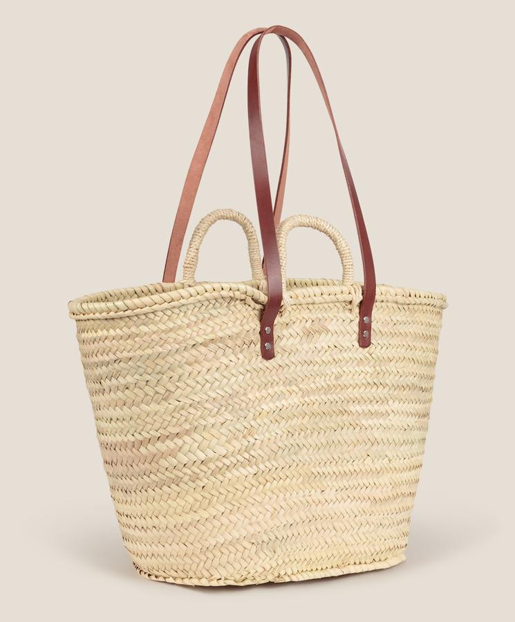 En color natural, este bolso tipo cesta de mimbre de tamaño grande cuenta con doble asa corta y una larga en piel de color marrón. Es de Oysho y tiene un precio de 29,99 euros.
