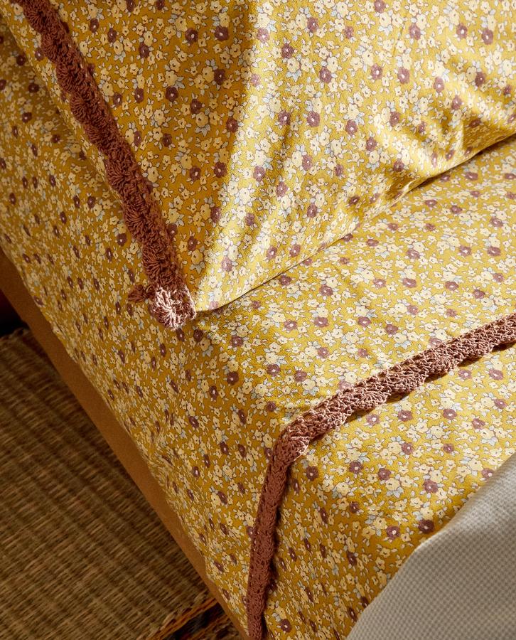 En color mostaza y con estampado floral, esta sábana encimera de algodón percal de 200 hilos cuenta con detalle de cenefa de crochet y está disponible en varias medidas. Su precio va desde los 12,99 euros. Cuenta sábana bajera y funda de almohada a juego.