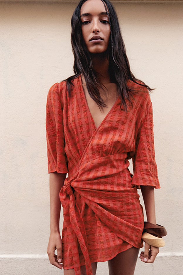 Vestido rojo cruzado, con escote de pico y lazada lateral, de Zara.