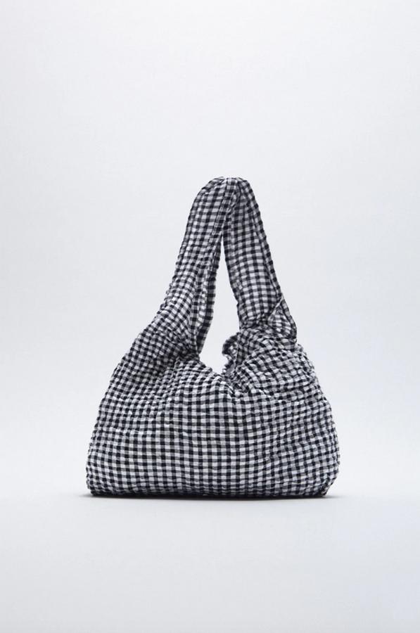 Este bolso en formato shopper en blanco y negro con estampado de Vichy es de Zara, de tamaño medio y con asas de hombro. Tiene cierre mediante imán y cuesta 12,95 euros.