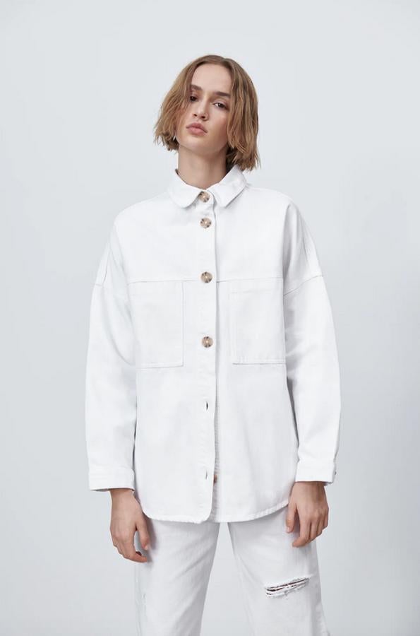 Confeccionada con al menos un 50% de algodón orgánico, esta sobrecamisa blanca de Zara con cuello de solapa y bolsillos delanteros de plastrón viene con cierre frontal de botones a contraste y podemos encontrarla entre las tallas XS y XL por 25,95 euros.