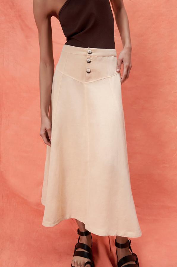 Esta falda de tiro alto de Zara está confeccionada con al menos un 50% de lino sostenible, tiene el bajo acabado en evasé y cierre frontal de botones a contraste. Cuesta 29,95 euros y está disponible entre las tallas XS y XL.