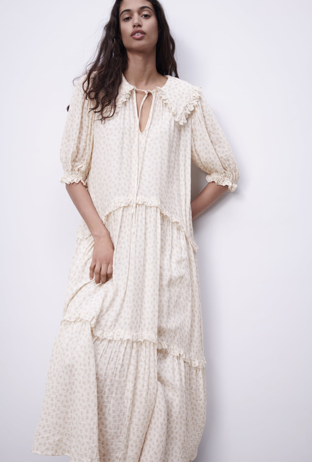 Vestido de gasa con un maravilloso estampado de flores en un tono neutro, con cuello redondo, escote en pico con lazada y manga por debajo del codo. Va adornado con volantes que marcan la cadera y el bajo de la falda. Está en la nueva colección de Zara (39,95 euros).