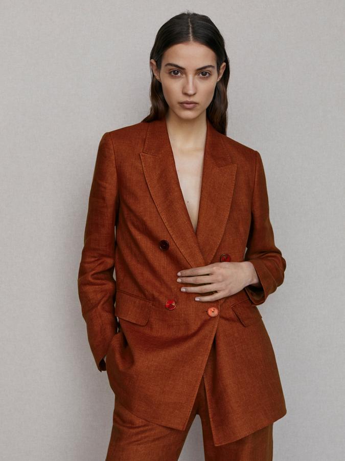 Confeccionada con lino sostenible, esta americana en color terracota de Massimo Dutti tiene cuello de solapa de pico, cierre cruzado mediante doble botonadura frontal, abertura trasera en el bajo, puños abotonados y bolsillos con solapa- Disponible entre las tallas 34 y 44, cuesta 129 euros.