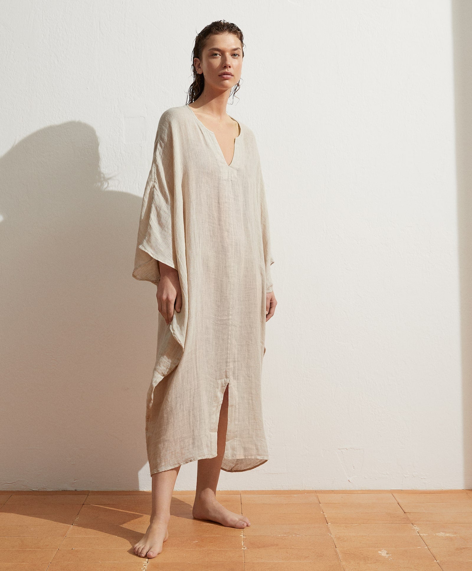 Caftán oversize de Oysho confeccionado con tejido de lino, escote a pico y abertura en el bajo. Todo en un color arena super bonito que querrás llevar 24/ con tu bronceado. (39,99 euros).