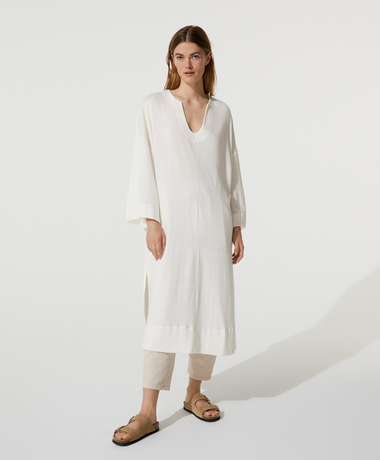 Túnica blanca lisa con escote a pico redondo, aberturas laterales y manga larga. Un básico de Oysho para llevar toda la temporada. (29,99 euros.