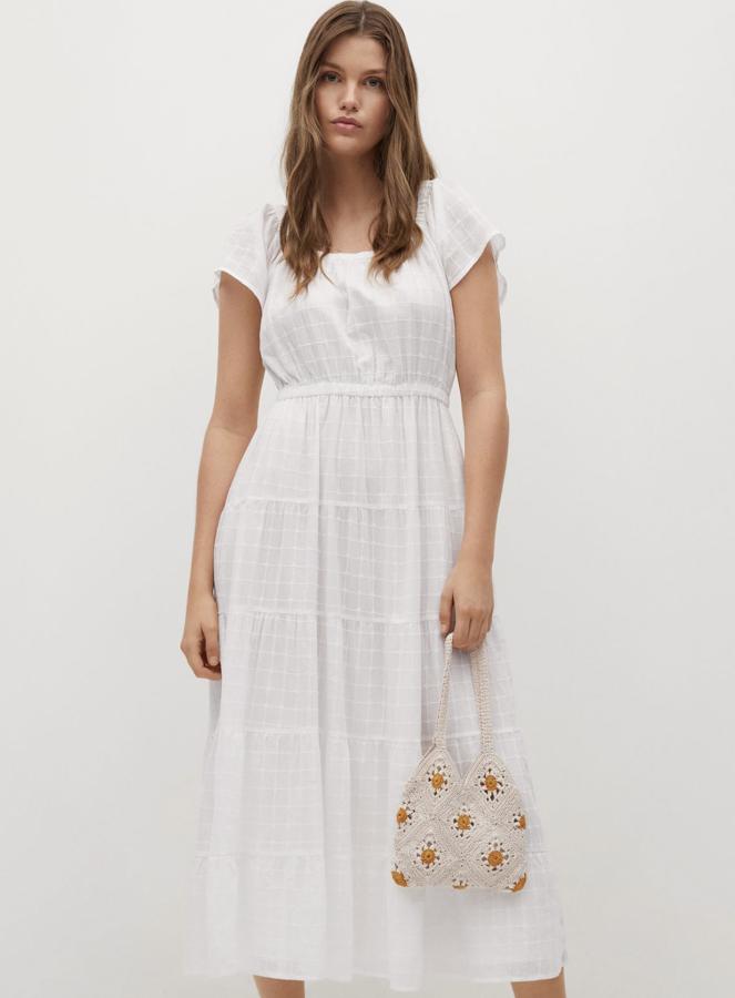 Confeccionado en 100% algodón, este vestido midi de color blanco con diseño acampanado y escote cuadrado cuenta con manga corta y cierre de lazo en la espalda. Es de Mango y tiene un precio de 49,99 euros.