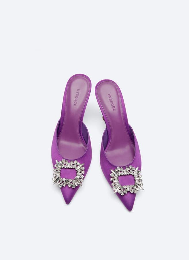 Diseño acabado en punta y detalle de joya en la pala. Estos zapatos de Uterqüe tienen el talón esculpido y forrado en raso morado; tanto el forro como la planta están elaborados con piel caprina. Son made in Spain y tienen un precio de 99 euros.