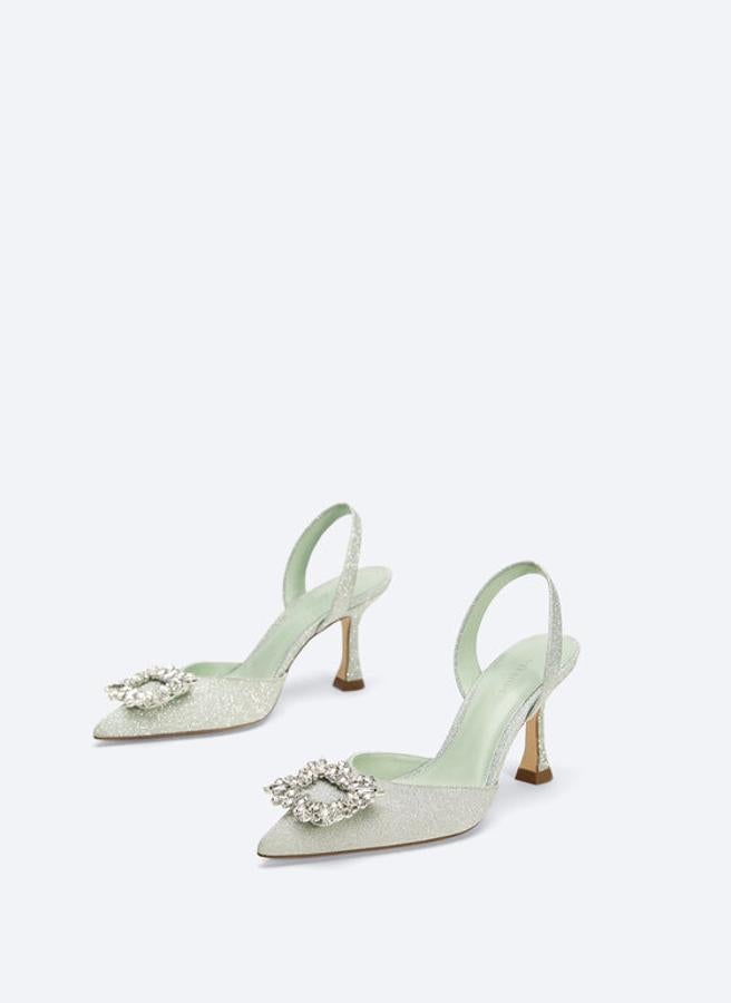 Zapato de tacón tipo sandalia en corte de tejido con glitter. Diseño acabado en punta y detalle de joya. Son de Uterqüe, made in Spain. Precio: 119 euros.