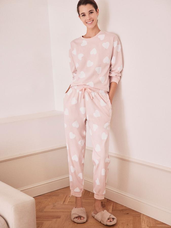 En color rosa con estampado de corazones en blanco, este conjunto de pijama está formado por una camiseta de manga larga y un pantalón largo con cintura elástica y cordones. Tiene un precio de 9,99 euros.