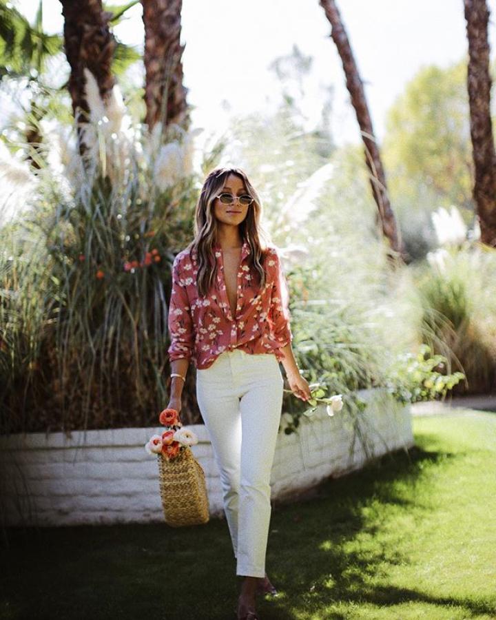 Con blusa con estampado de flores y bolso de rafia