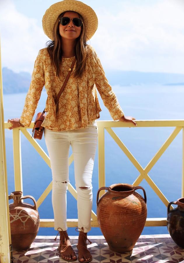 Con blusa estampada y sandalias planas con tiras