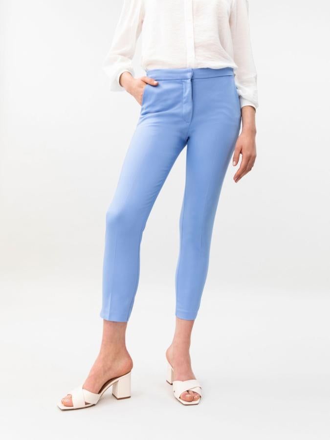 Este pantalón de vestir tobillero en color azul está disponible en otros colores. Con goma elástica en la espalda y cierre delantero con cremallera y pasador, tiene un precio de 14,99 euros.