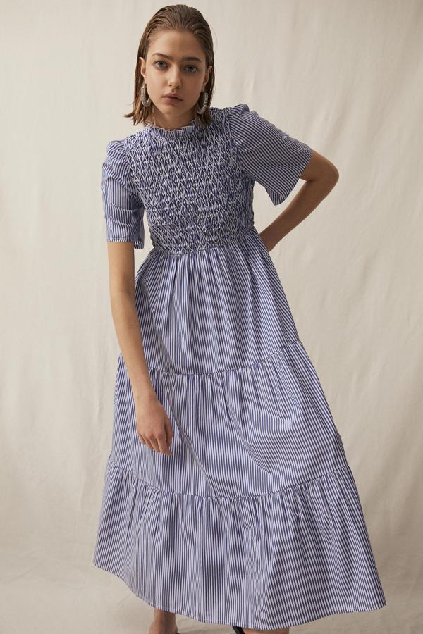 Este vestido midi con estampado de rayas en blanco y azul cuenta con cuello perkins, elástico en la zona del pecho y manga corta. Tiene un precio de 29,99 euros.